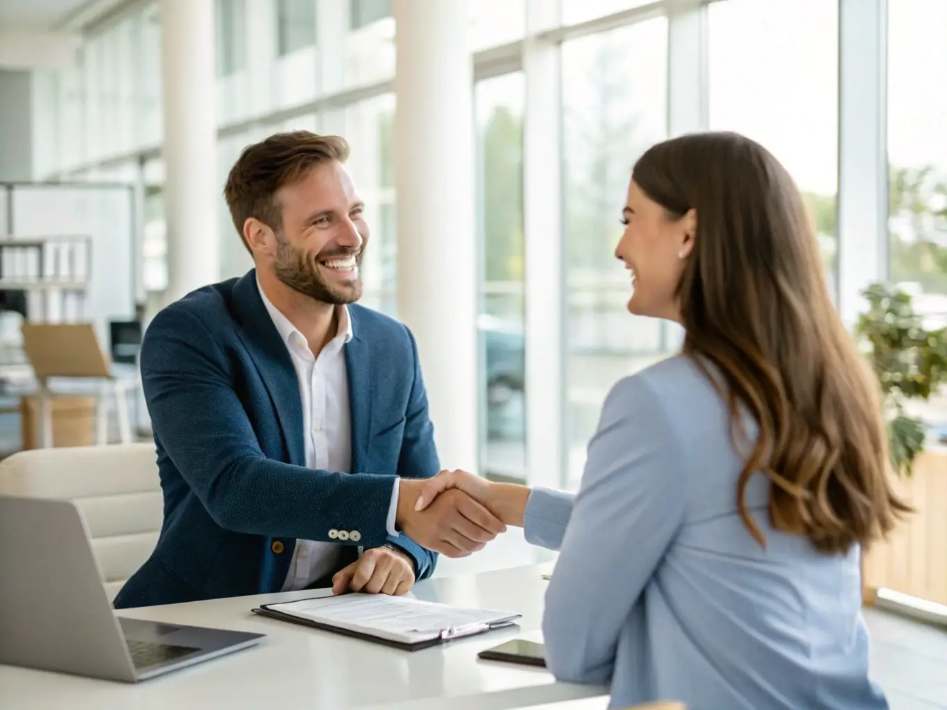 A friendly insurance agent shaking hands with a client in a bright, modern office, symbolizing trust and personalized service.