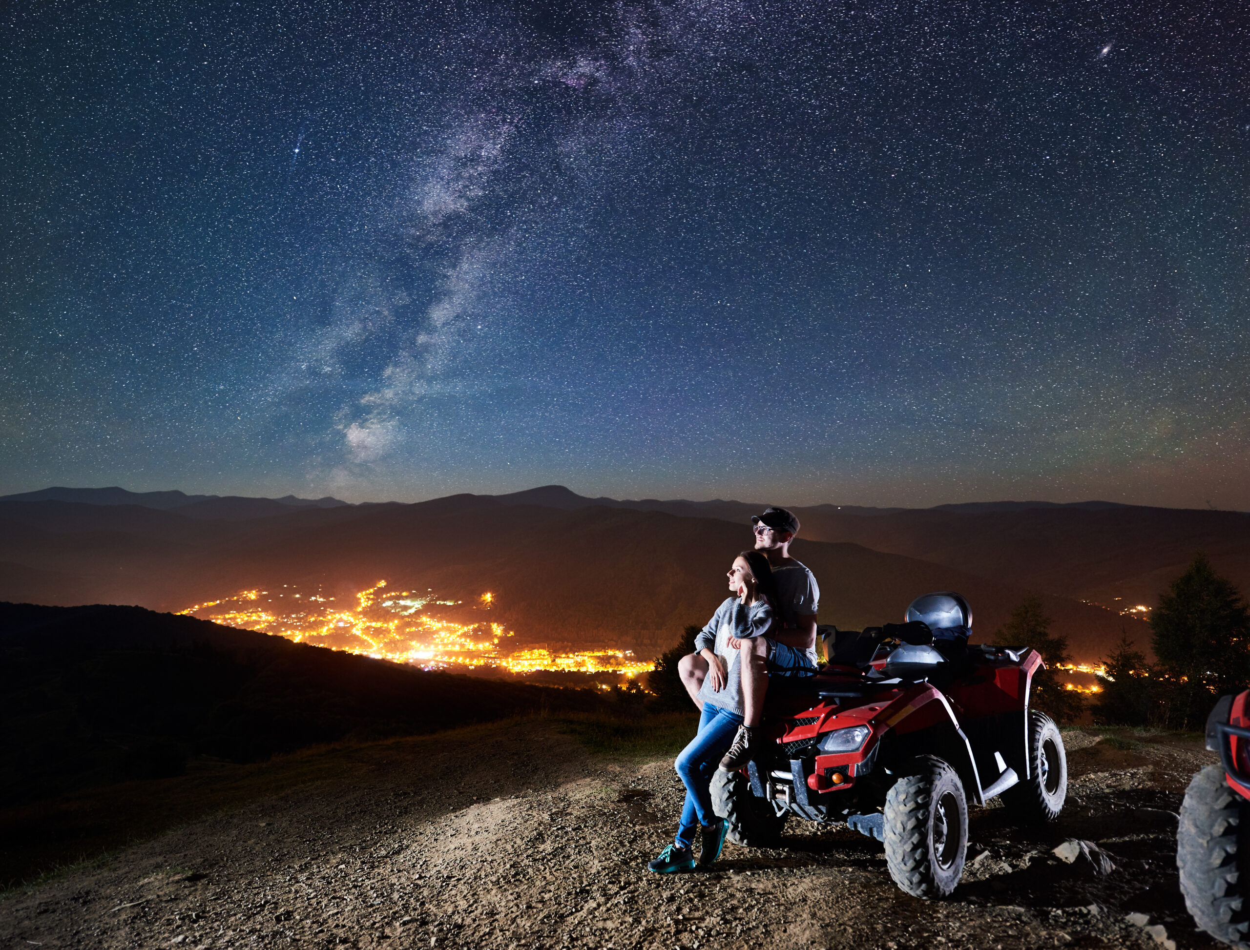 Active man and woman travelers with atv quad motorbike on the top of mountain
